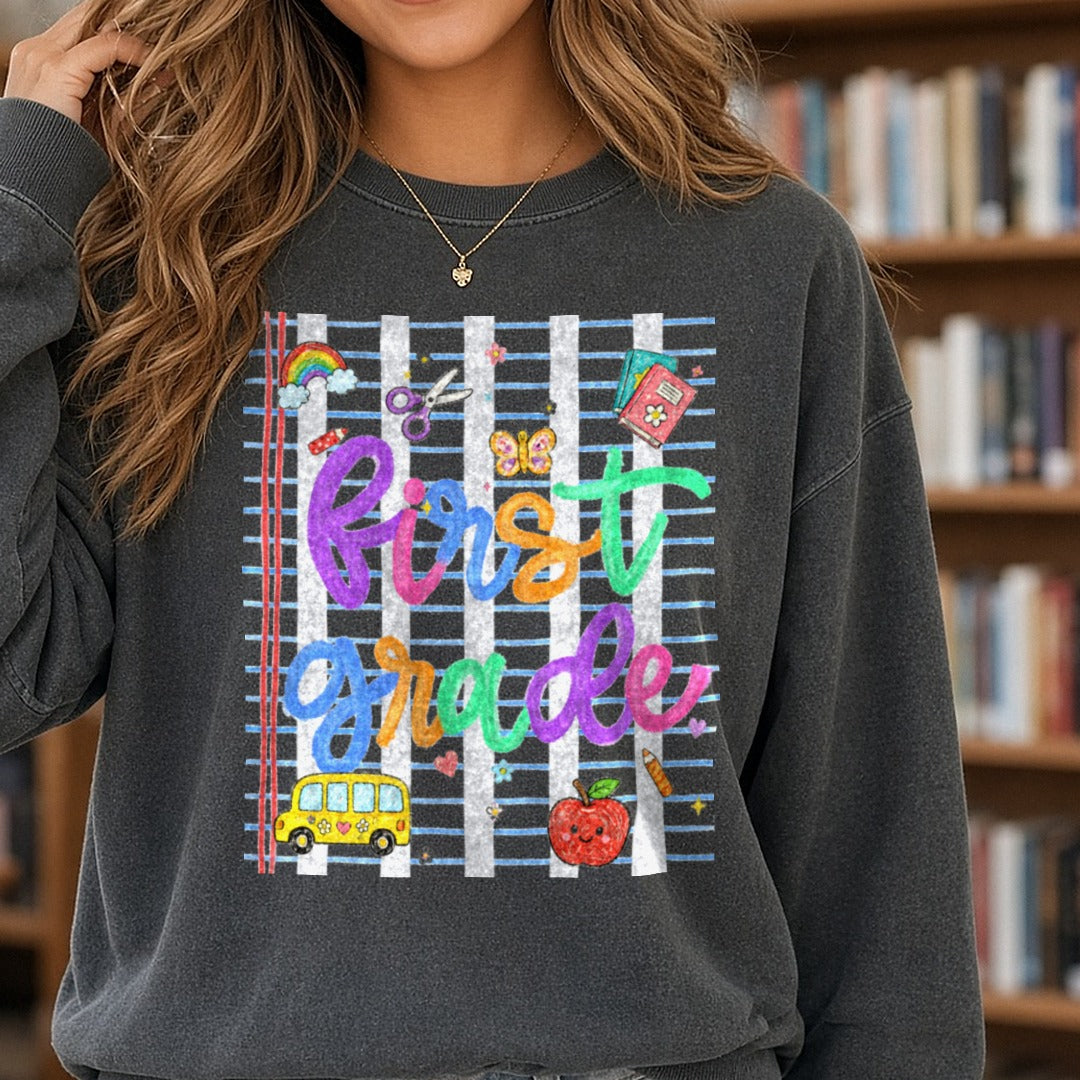Colorful First Grade Hand Lettered School Supplies Design DTF transfer shown on a Comfort Colors sweatshirt