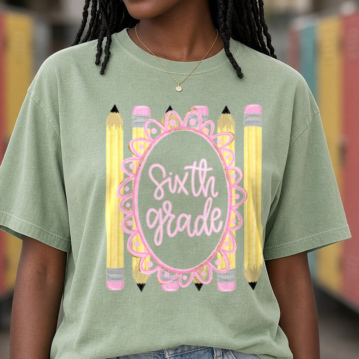 Sixth Grade Pink Script Oval Frame Yellow Pencils DTF transfer shown on a Comfort Colors tee