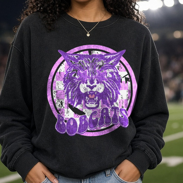 Purple Bobcats Mascot Checkered Circle Logo DTF transfer shown on a Comfort Colors sweatshirt