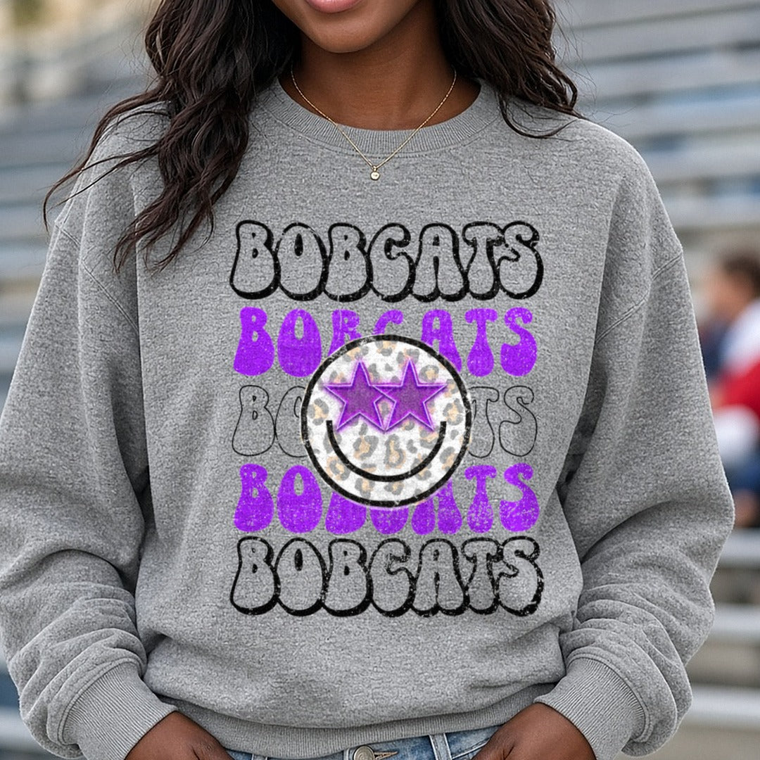 Bobcats Stacked Retro Bubble Letter Purple Leopard Smiley DTF transfer shown on a Comfort Colors sweatshirt