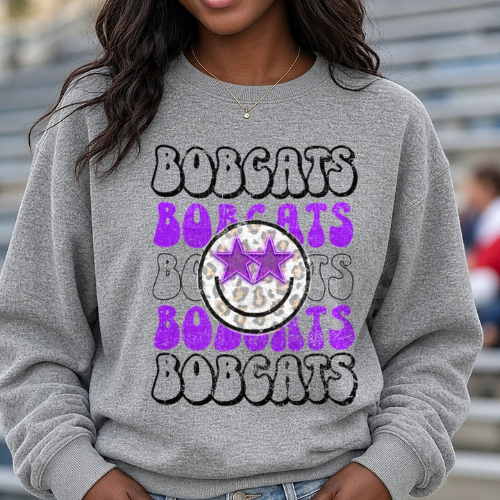 Bobcats Stacked Retro Bubble Letter Purple Leopard Smiley DTF transfer shown on a Comfort Colors sweatshirt