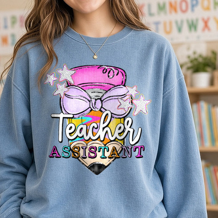 Teacher Assistant Colorful Pencil Purple Bow Stars Design DTF transfer shown on a Comfort Colors sweatshirt