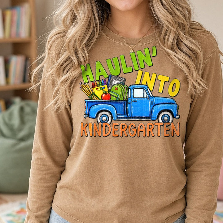 Haulin Into Kindergarten Vintage Blue Truck School Supplies DTF transfer shown on a Comfort Colors long sleeve tee