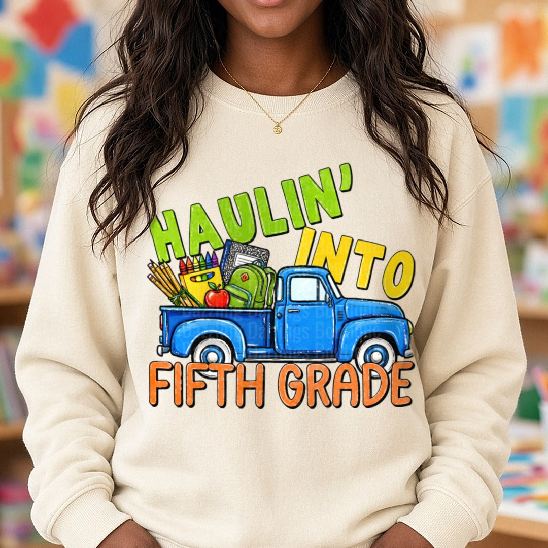 Haulin Into Fifth Grade Vintage Blue Truck School Supplies DTF transfer shown on a Comfort Colors sweatshirt