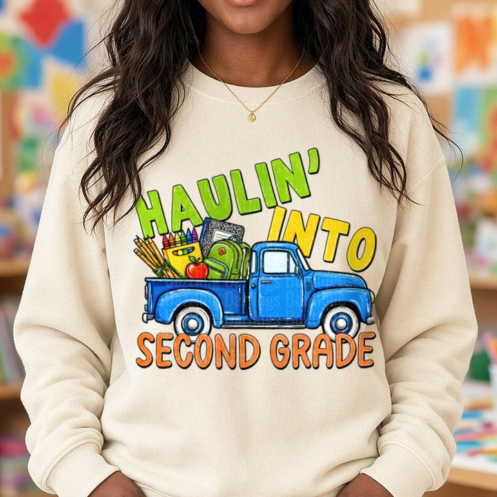 Haulin' Into Second Grade Blue Vintage Truck School Supplies DTF transfer shown on a Comfort Colors sweatshirt