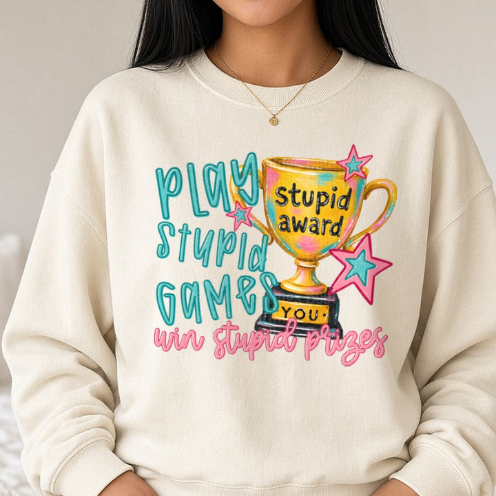 Play Stupid Games Win Stupid Prizes Trophy Award DTF transfer shown on a Comfort Colors sweatshirt