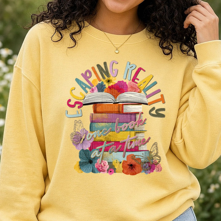 Escaping Reality One Book At A Time Floral Book Stack DTF transfer shown on a Comfort Colors sweatshirt